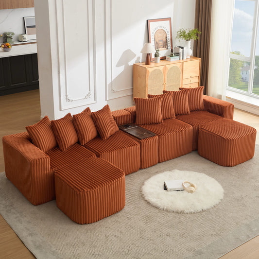 An_oversized_orange_u_shaped_sofa_in_soft_corduroy_featuring_movable_modular_seating_a_footstool_USB_and_wireless_charging_plus_a_coffee_table_board_with_cup_holders_for_stylish_every