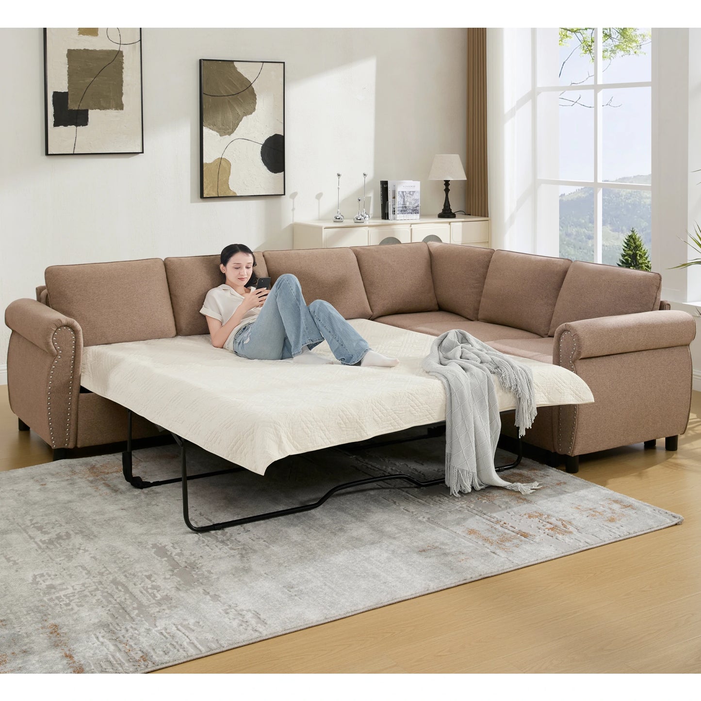 Brownsectionalsleepersofabedwithapersonrelaxingonthepull-outbedinamodernlivingroom